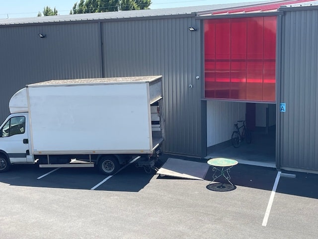 Photo du déchargement d'un camion de déménagement avec un haillon devant un box de 9m² (25m3) de Lockn'box.